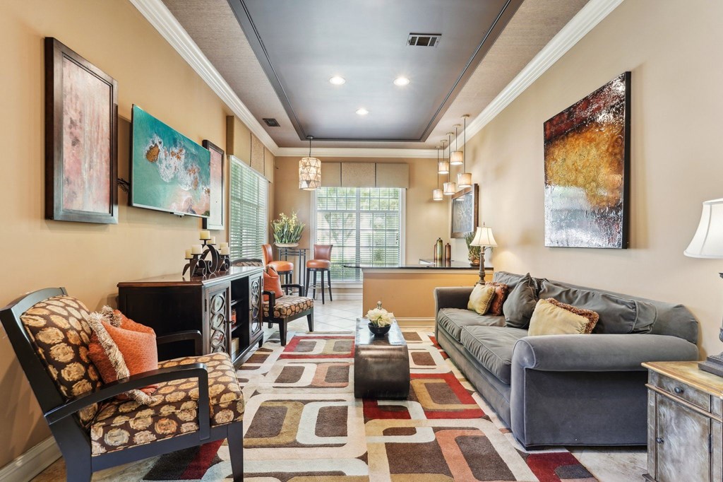 Resident lounge with a TV, couch, chairs, bar area with more seating