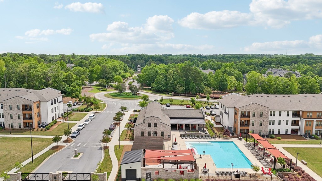 A large apartment complex with a swimming pool in the middle and many covered lounge areas