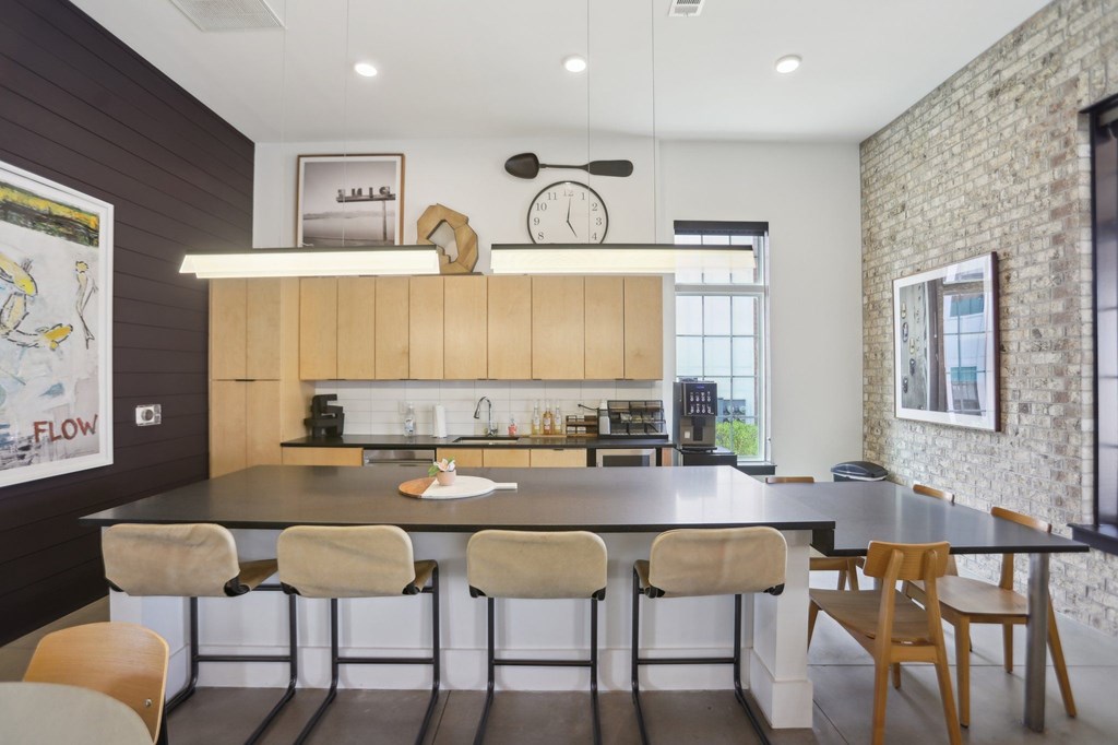 A kitchen with a large island and chairs in resident clubhouse