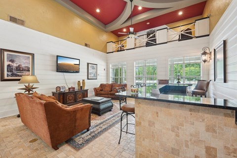 A living room with a brown couch and a television on the wall.