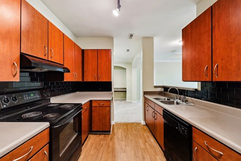 A kitchen with wooden cabinets and black appliances.