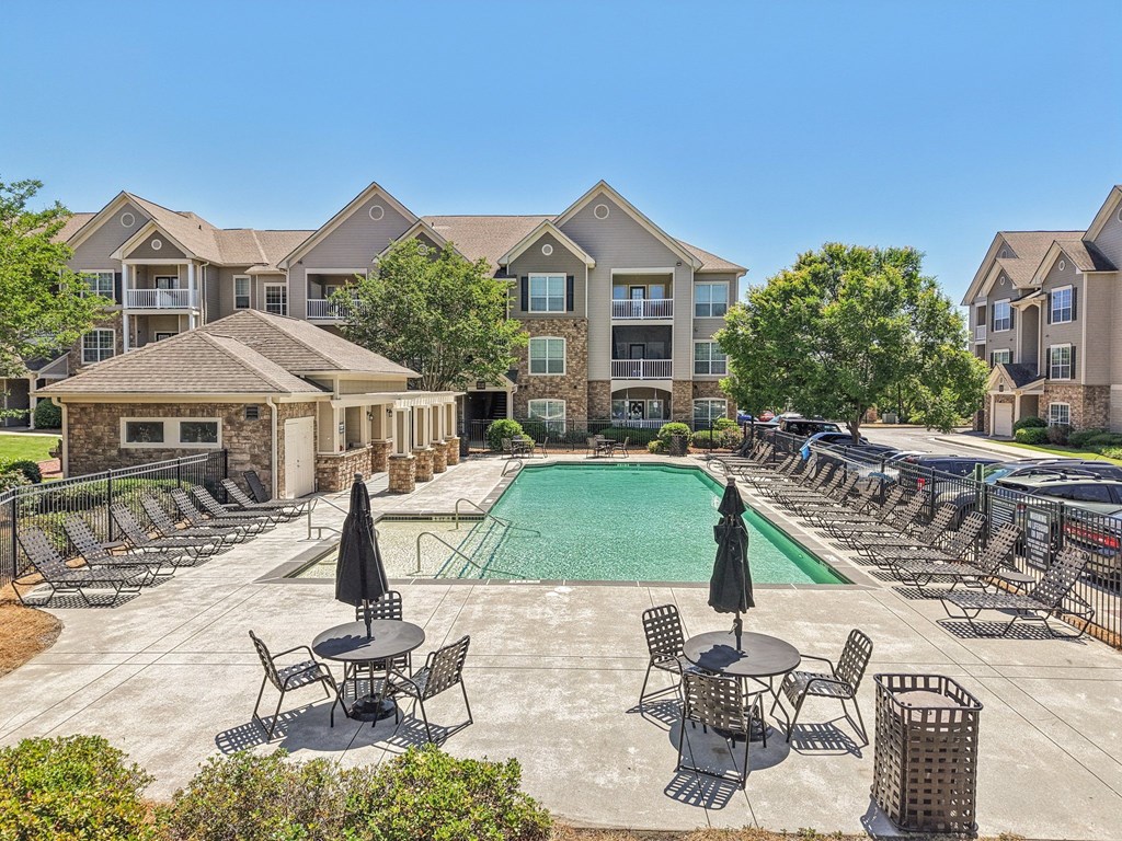 pool with lounge chairs and tables with umbrellas