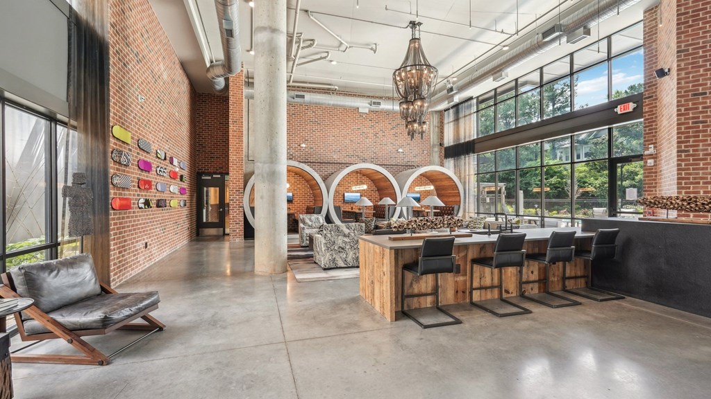 Resident clubhouse with bar seating, wine fridge, many seating areas with couches, work booths, and chairs