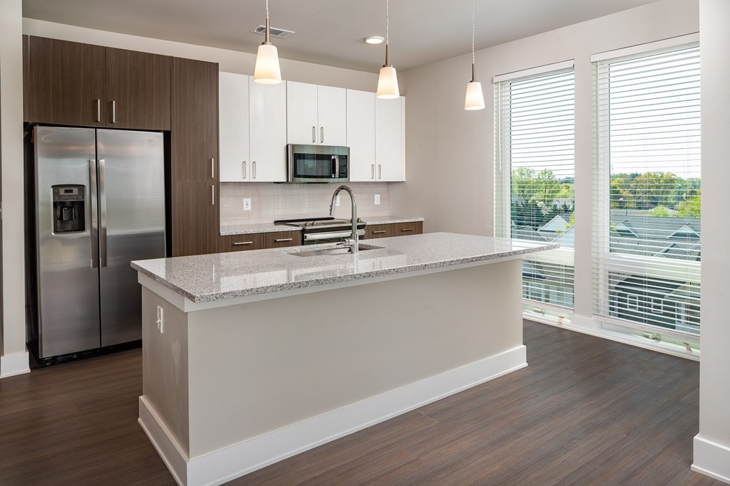 A modern kitchen with a stainless steel appliances and floor to ceiling windows