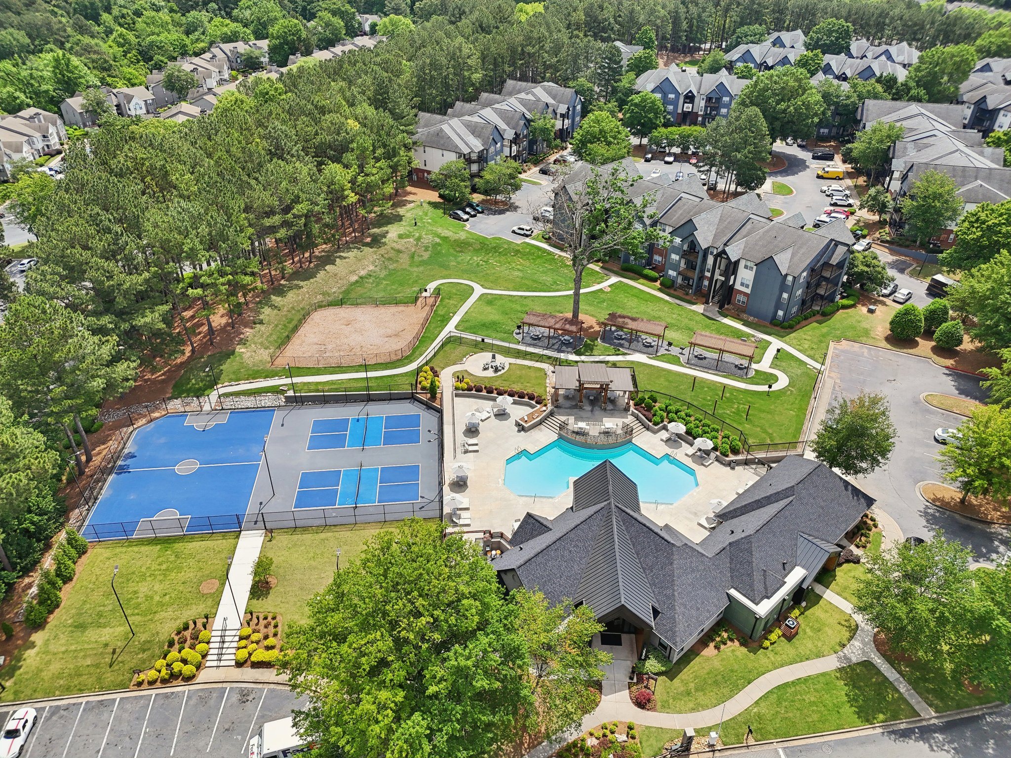 A bird's eye view of a residential area with a swimming pool and tennis court.