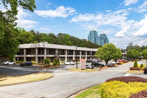 A parking lot with cars and a building in the background.