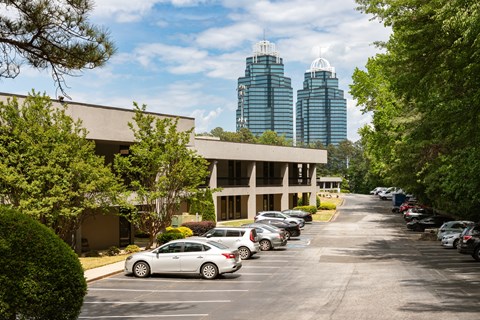 A parking lot with cars and a building in the background.