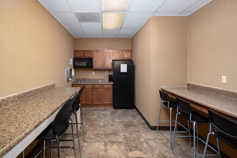 A kitchen with a black refrigerator, microwave, and oven.