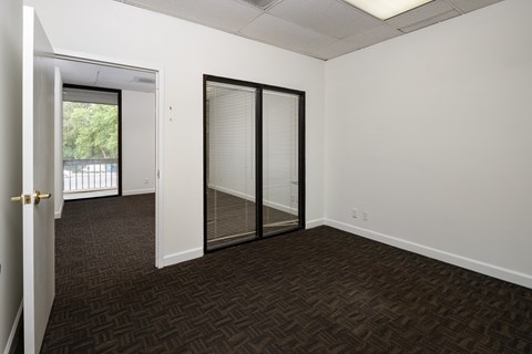 A room with a carpeted floor and a sliding glass door.