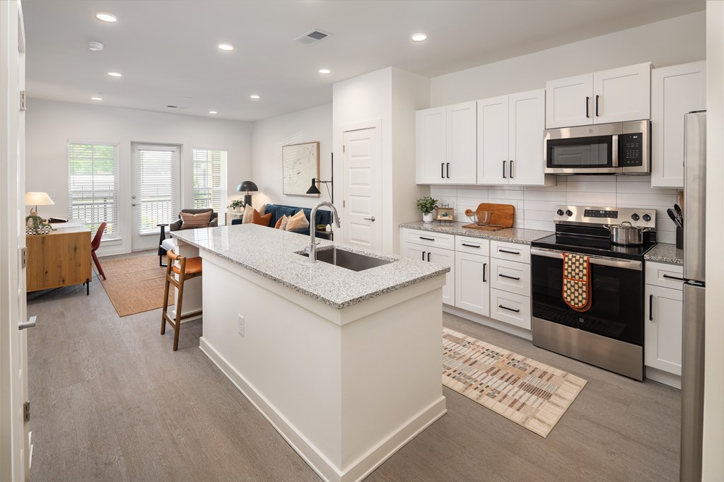 A kitchen with white cabinets and a large island.