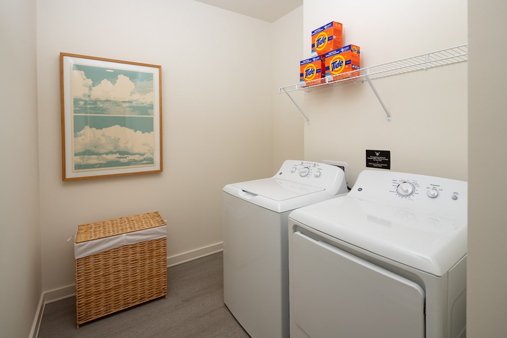 A laundry room with two washing machines and a basket.