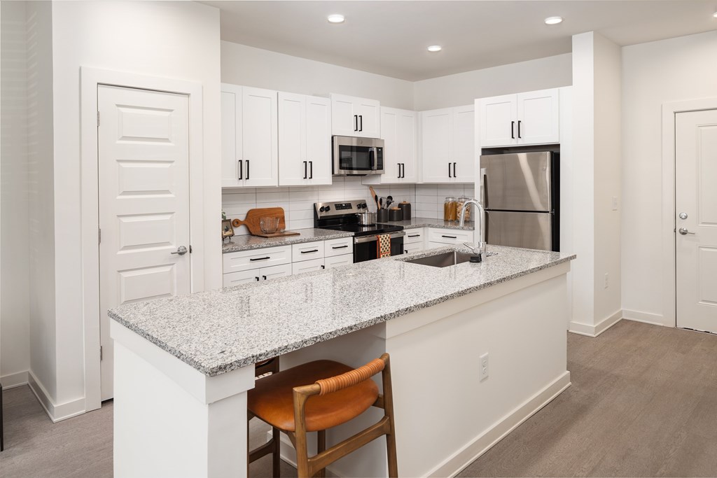 A kitchen with a white countertop and a refrigerator.