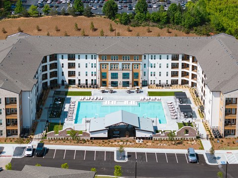 An aerial view of a large building with a pool in the middle.