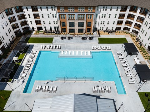 A large swimming pool surrounded by apartment buildings.