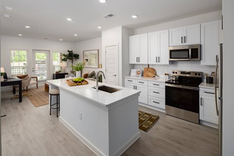 A modern kitchen with white cabinets and stainless steel appliances.