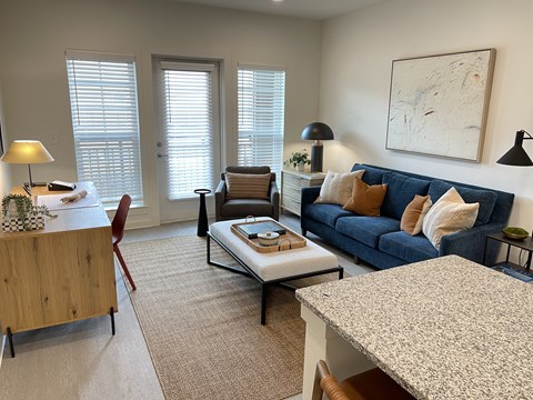 A living room with a blue couch and a coffee table.