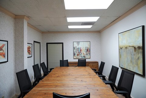 A conference room with a long table and chairs.