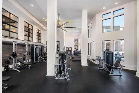 A gym with a variety of equipment and a large mirror on the wall.