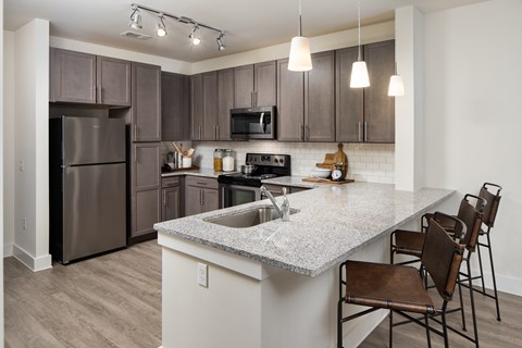 A modern kitchen with wooden cabinets and a granite countertops