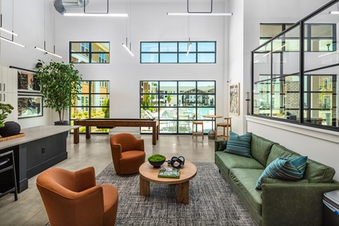 A modern living room with a green couch and orange chairs.