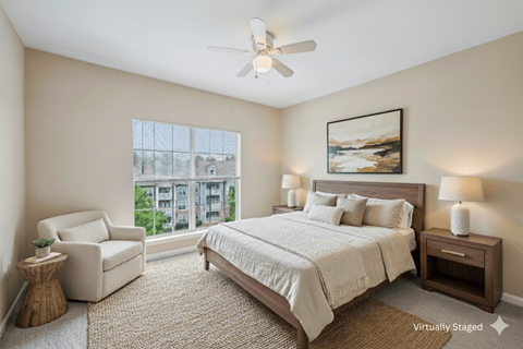 A bedroom with a large bed, a chair, and a painting on the wall.