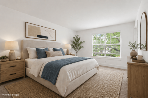 A bedroom with a large bed, a nightstand, and a mirror.