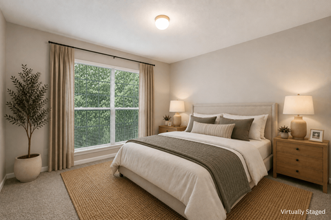 A bedroom with a large bed, a nightstand, and a window with a view of trees.