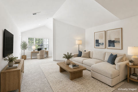 A living room with a couch, a chair, a coffee table, and a television.