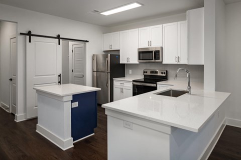 a kitchen with white counters and white cabinets and stainless steel appliances