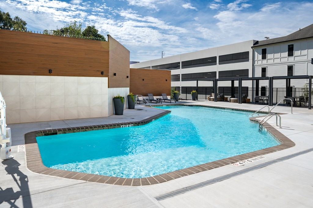 A small pool with a brown wall and a white wall behind it.