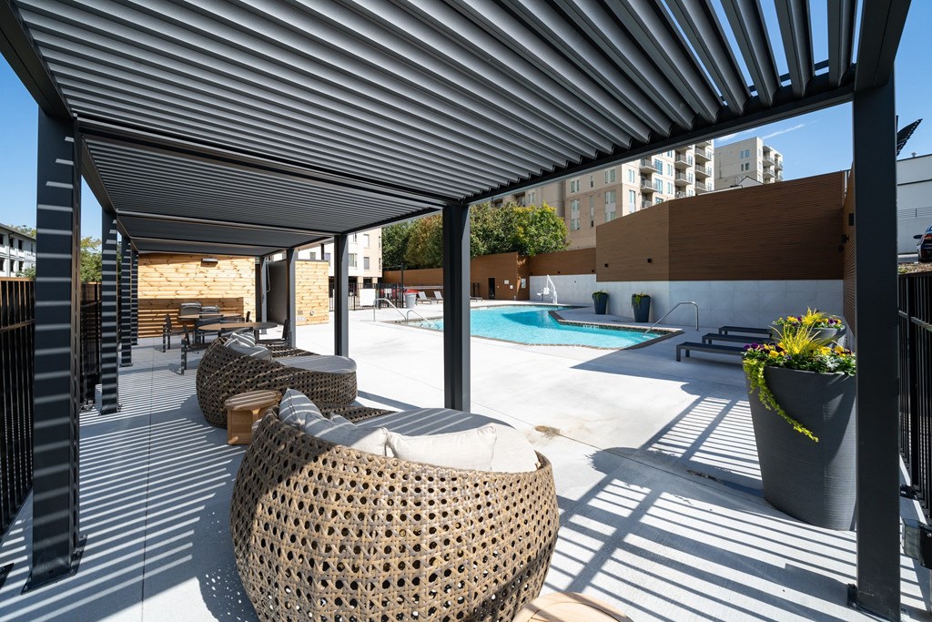 A patio with a pool and sun loungers.