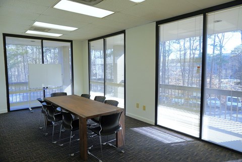 A conference room with a long table and chairs.