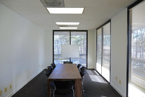 A conference room with a long table and chairs.