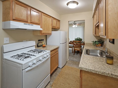 A kitchen with a white stove and a white refrigerator.