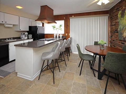 A kitchen with a black refrigerator and a white counter.
