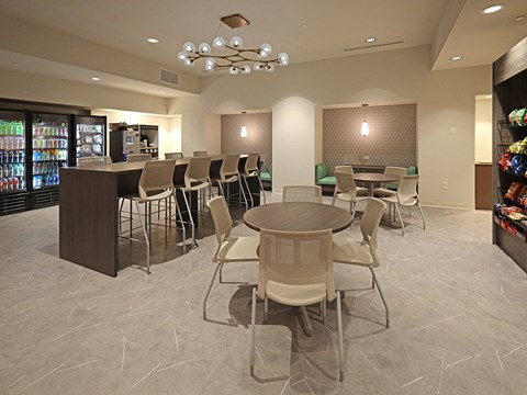 Community cafe with modern seating and beverage coolers at Residences at 55 Apartments, Cleveland, Ohio