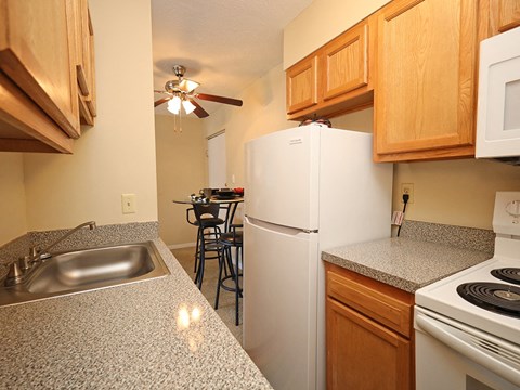 A kitchen with a white refrigerator and a stove top oven.
