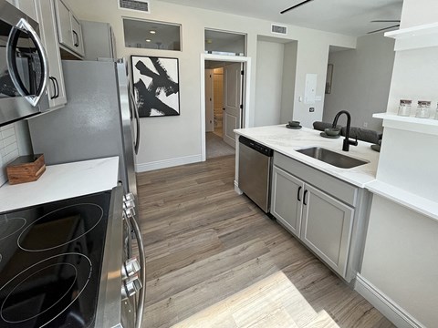 a renovated kitchen with white cabinets and stainless steel appliances