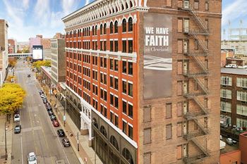 A large building with a banner that says "We have faith in Cleveland" on it.