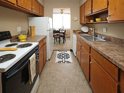 Galley kitchen with electric stove and brown countertops at Harbor Crest Apartments, Ohio, 44123