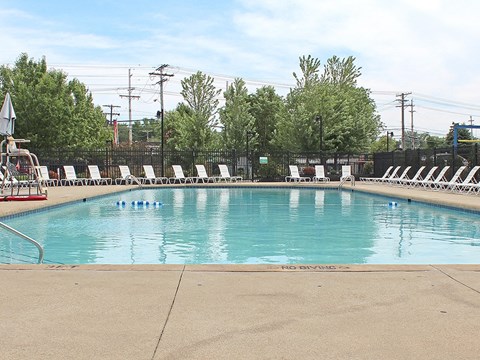Outdoor swimming pool with lounge chairs at Water's Edge Apartments, Euclid
