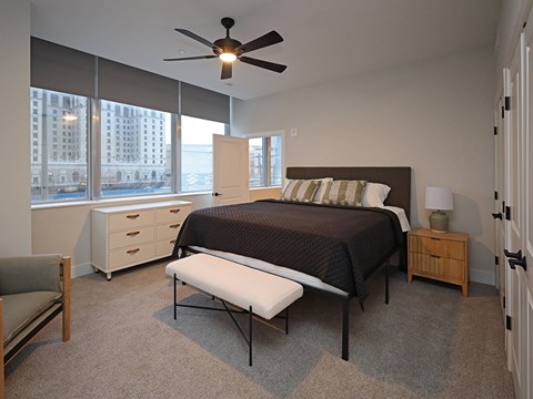 Bedroom with dark bedding and ceiling fan at Residences at 55 Apartments, Cleveland, 44113
