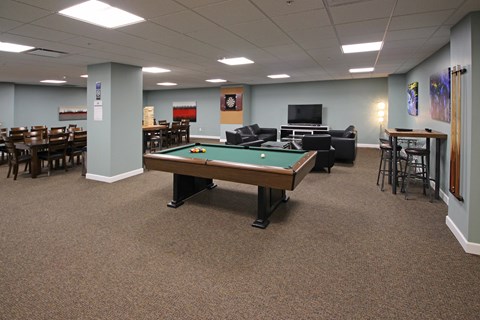 A room with a pool table and a TV.
