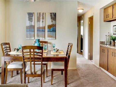 Dining room with wood furniture and wall art at Trinity Towers Apartments, Ohio