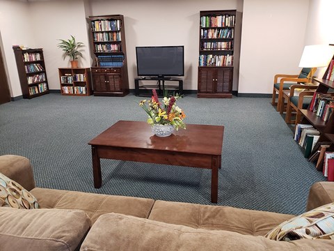 A living room with a couch, a coffee table, and a television.