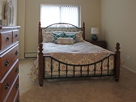 a bedroom with a bed and a dresser and a window