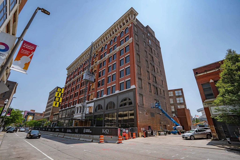 A large red brick building with a crane in front of it.