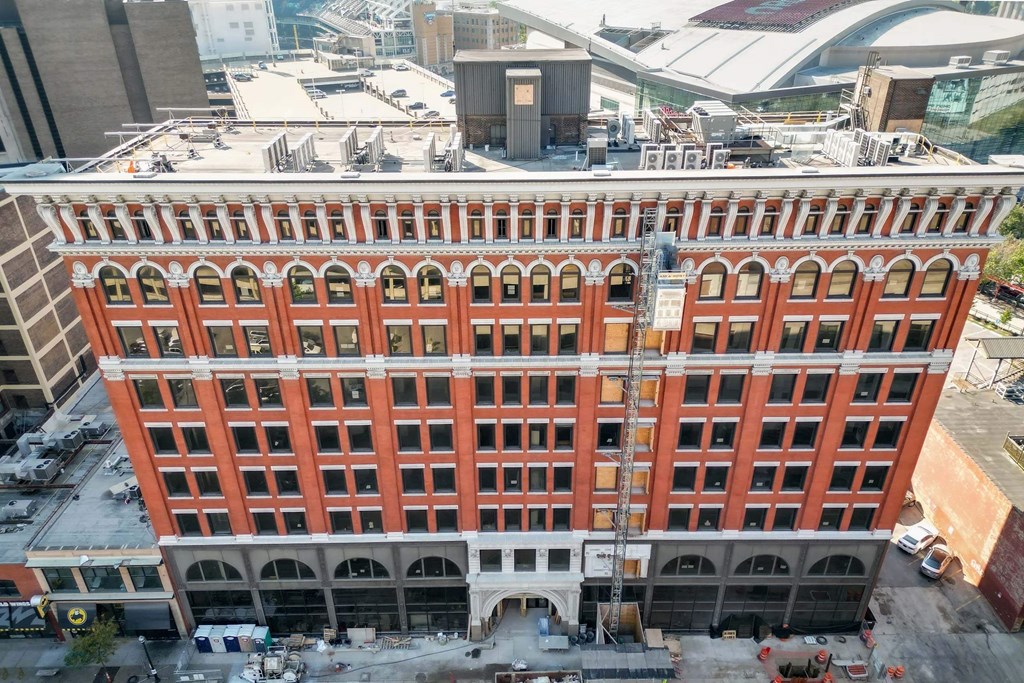 A large red brick building with many windows and a crane in front of it.