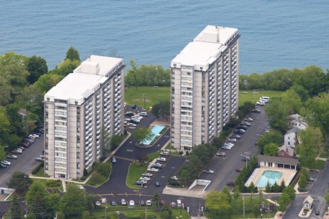 Two identical buildings are situated next to each other with a pool in the middle.