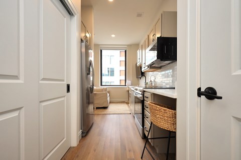 A kitchen with white cabinets and a refrigerator.